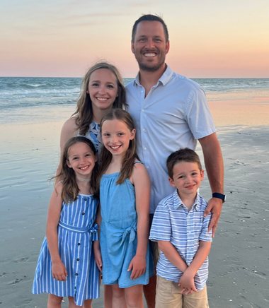 Dane Cookson with his wife and three children on a beach